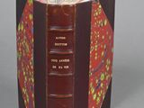 an open book with a red cover sitting on top of a table