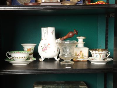 many cups and saucers on a shelf in a room