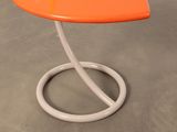 an orange and white side table with a curved base