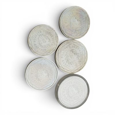 quatre assiettes blanches ornées de motifs, posées sur un fond blanc