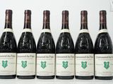 six bouteilles de vin sont alignées sur une table