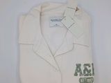 polo blanc avec un logo vert et blanc sur la poitrine