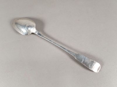 une cuillère en argent avec un manche de cuillère sur une table