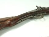 a close up of a rifle on a table with a knife