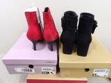 two pairs of red and black high heeled shoes on a box