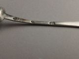 a silver spoon with a spoon handle on a table