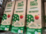 four cartons of fruit juice sit on a shelf in a grocery store
