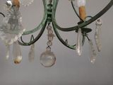 a green chandelier with a bunch of glass beads hanging from it