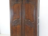 an image of a wooden armoire with carvings on the doors