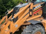 a backhoe of a tractor that is parked in the grass