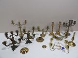 many different types of brass candlesticks on the table