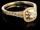 un gros plan d'une bague sertie d'un diamant jaune et entourée de diamants