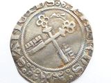 an old silver coin with a cross on it sitting on a white surface