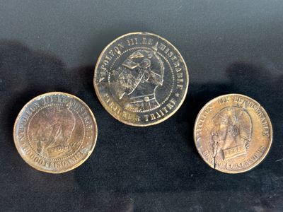 three different types of coins sitting on a black surface