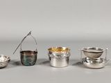 four silver cups and spoons are lined up on a table