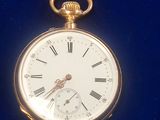 a gold pocket watch with roman numerals on it