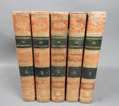 five old books sitting on top of each other on a table