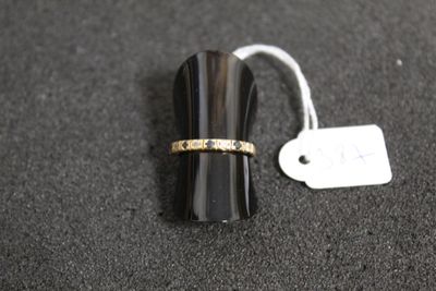 une bague ornée d'un anneau en or, à côté d'une étiquette de prix