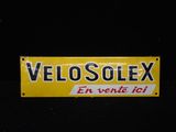 un panneau jaune sur lequel est inscrit « Velosolex »