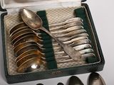 silverware in a green case with green handles and spoons on a table