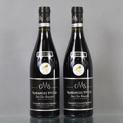 two bottles of wine sitting on top of a table next to each other