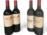 trois bouteilles de vin rouge sont posées les unes à côté des autres sur une surface blanche