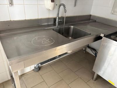 a stainless steel sink in a kitchen with a stainless steel counter top