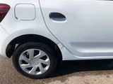 a small white car that is parked in a parking lot