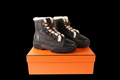 a pair of black boots sitting on top of an orange box
