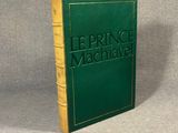 a green book sitting on top of a table next to a gray wall
