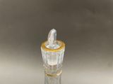 a small glass bottle with a gold rim on a table