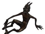 statue en bronze représentant un homme assis par terre, les jambes croisées