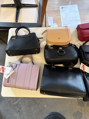 a lot of purses sitting on a table in a room