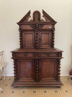 une armoire en bois posée au milieu d'un sol carrelé
