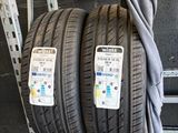 two tires on a rack in a garage with a sign on the wall