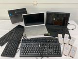 several laptops, keyboards, mouses, and other electronic devices are on a table