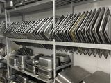 de nombreuses casseroles et poêles sur les étagères de la cuisine