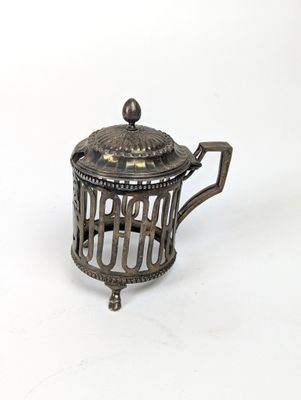 une théière ancienne en argent surmontée d'une cage à oiseaux