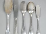 four spoons, a fork, and a knife on a table
