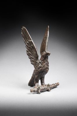 une image représentant une statue en bronze d'un oiseau perché sur une branche