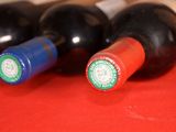 three bottles of wine sitting on a red table