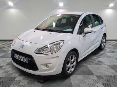 la voiture blanche est garée sur un sol en damier dans le garage