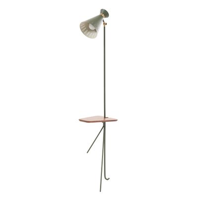le lampadaire repose sur un pied, avec une table en bois en dessous
