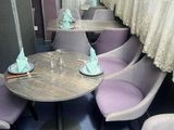 many chairs and tables in a restaurant with curtains on the windows