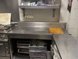 une grande cuisine en inox équipée d'une cuisinière et d'un évier