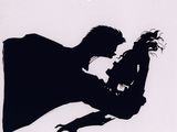 the silhouette of a man and a woman are kissing in the dark