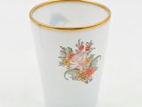 a white cup with a gold rim and a flower design on it