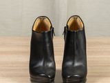 the back of a pair of black leather ankle boots on a wooden surface
