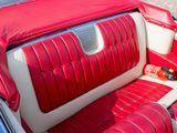 an image of a red and white car with the door open