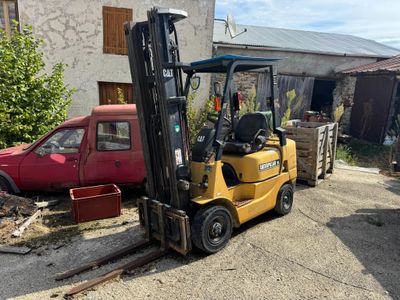 a yellow forklift truck parked in front of a building